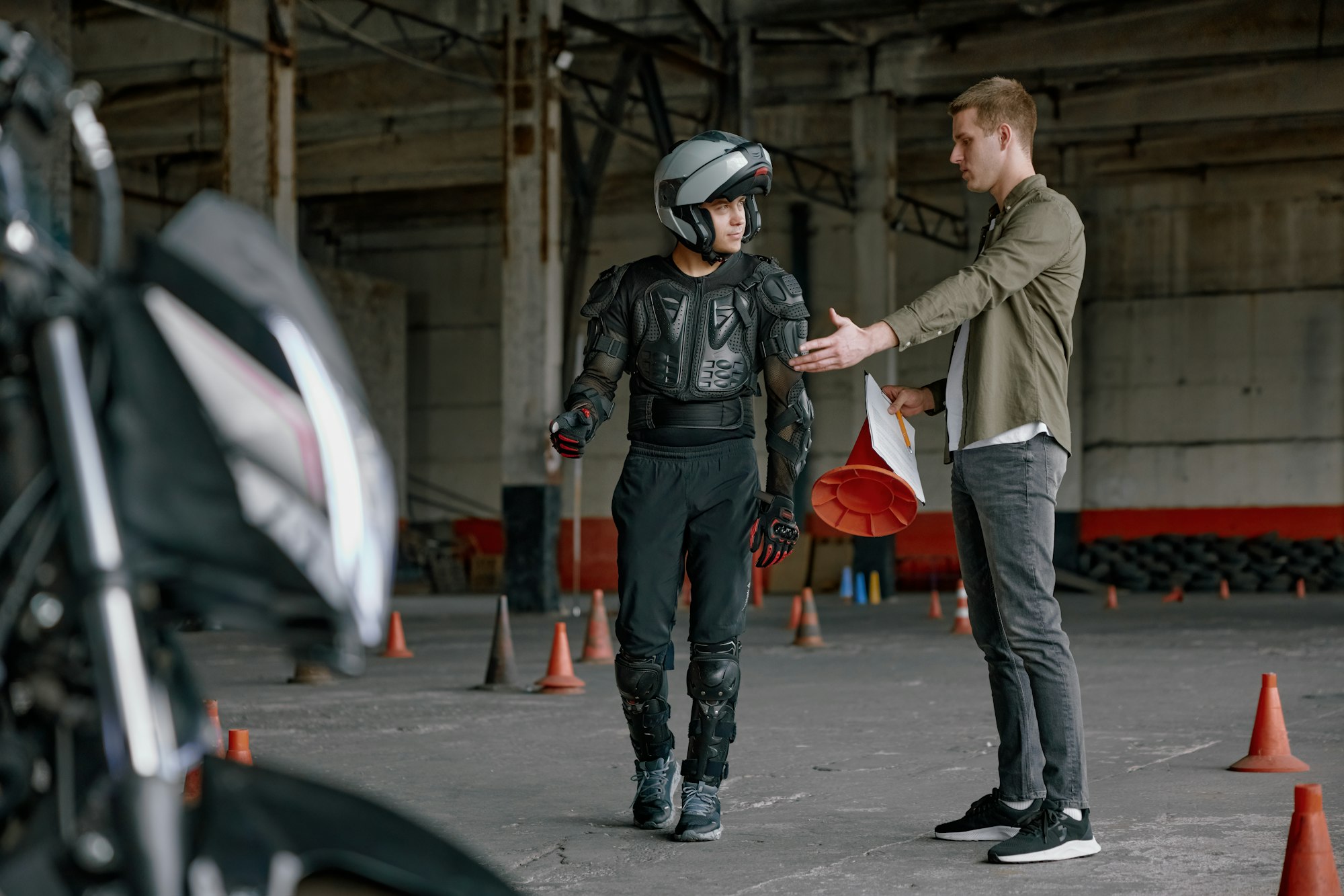 Student motorcyclist and instructor discussing rout of future exam race